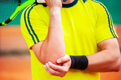 Joueur de tennis ayant mal a son coude et le tien tendinite coude tennis| IK Paris