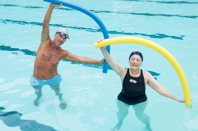 Couple de personne agees faisant du sport dans une piscine - balneo dos| IK Paris